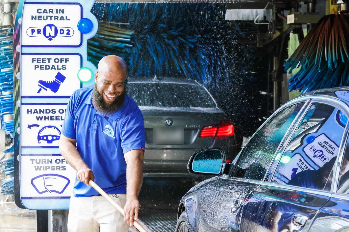 A Zoom Express attendant laughing as he preps a car at the tunnel entrance