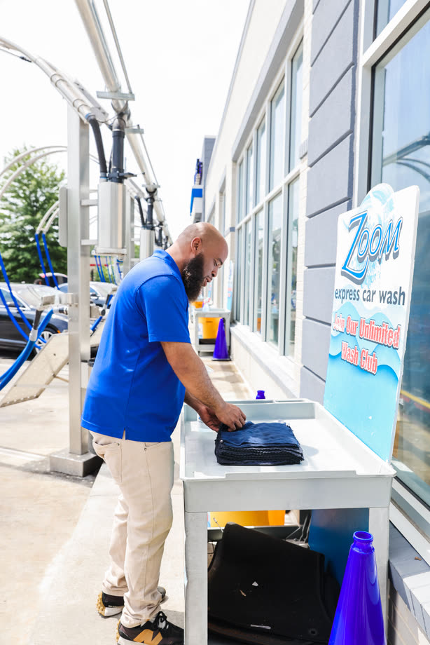 A Zoom Express team member working at a table outside the building, by the vacuum arches