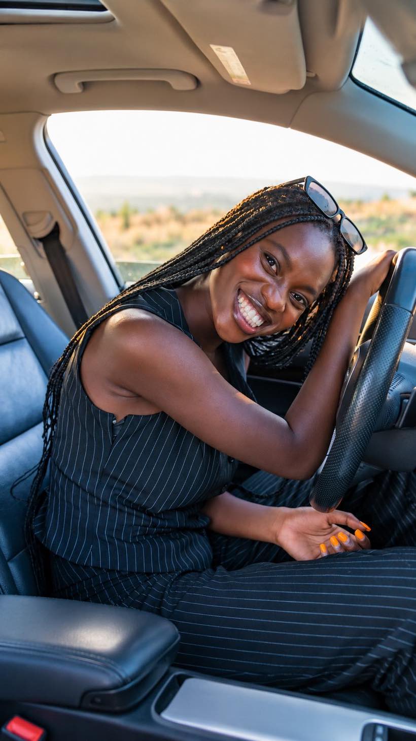 A Zoom Express member smiling at the wheel of her freshly washed car